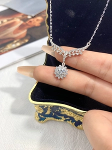 Macro shot of silver sunflower wing pendant with sparkling crystals on jewelry box