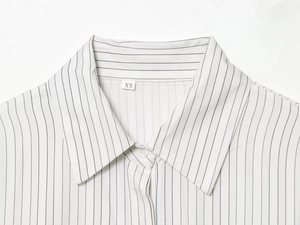 Detail of striped shirt collar and black vertical lines with size XS label shown