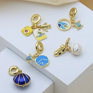 Gold-plated enamel charms featuring turtle, airplane, and basketball on geometric stands