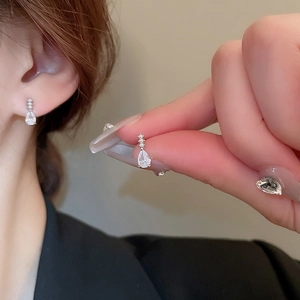 Élégantes boucles d'oreilles goutte en zircon et perles portées par un mannequin