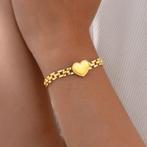 Polished gold heart charm bracelet with flat rectangle links on female model's wrist