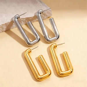Minimalist rectangular hoop earrings in gold and silver finish on natural stone background