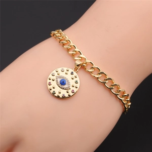 Detail of gold evil eye bracelet featuring vibrant rhinestones and Cuban link chain