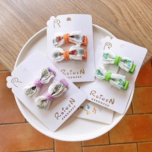 Three pairs of handmade embroidered flower bows on white cards for girls hair styling