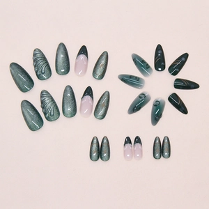 Macro view of green cat-eye press-on nails with 3D shell texture and French tips