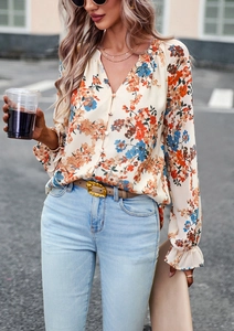Dettaglio di elegante camicia floreale con scollo a V, polsini a balze e stampe vintage