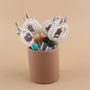 Detail of beaded ballpoint pens with pearl-encrusted charm tops and cartoon prints