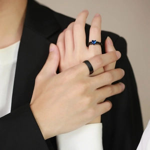 Black titanium couple rings set featuring a sleek band and a blue heart-shaped gemstone