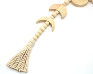Dettaglio delle perle in legno boho con nappe in cotone e ciondolo a forma di luna