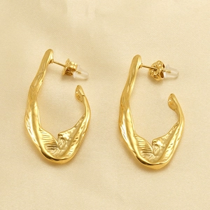 Detail of irregular 18K gold plated stainless steel earrings on champagne silk fabric