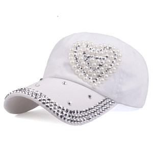 Women's white baseball cap with pearl heart and rhinestone brim shown from a side angle