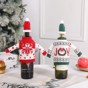 Knitted Christmas wine bottle covers set with snowflake and JOY text in festive setting