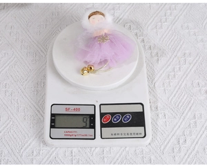 Detail of Christmas fairy ornament in purple tulle skirt weighing 9g on digital scale