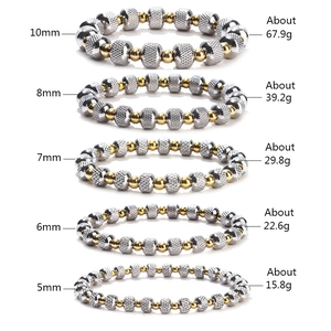 Two-tone stainless steel beaded bracelet stack in gold and silver textured grid finish