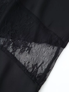 Close-up of elegant floral lace texture and stitching detail on a black V-neck dress