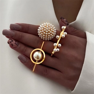 Set of gold rings with pearls featuring geometric designs and minimalist clusters