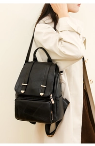 Detail eines schwarzen Rucksacks aus strukturiertem Kunstleder mit Goldbeschlägen