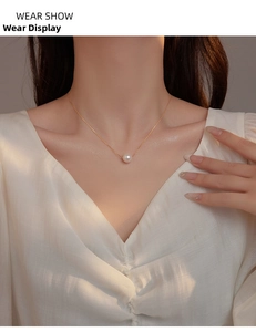 Detailed view of an elegant S925 silver necklace with a round pink shell pearl on a model