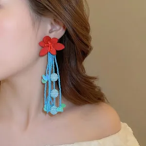 Floral tassel earrings featuring red fabric petals and blue long beaded fringe strands