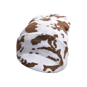 Detailed view of the soft knitted fabric and brown cow print pattern on a winter beanie