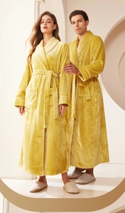 Detailed view of plush gold flannel robes with white piping and waist tie for couples