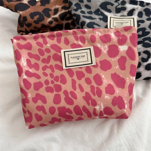 Dettaglio delle pochette in tela leopardata nei colori rosa, marrone e nero con etichette