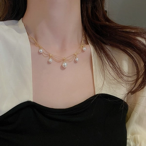 Close-up of multi-layer gold plated pearl tassel necklace on a fashion model
