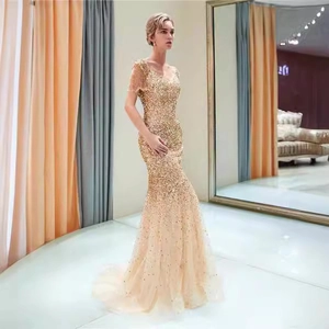 Elegante abito da sera a sirena con paillettes oro, scollo a V e maniche con frange moda