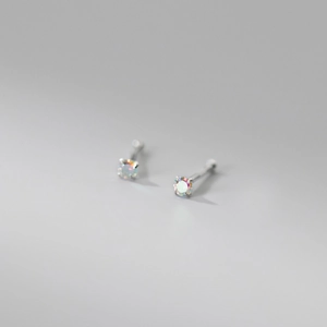 Macro shot of 999 sterling silver stud earrings with iridescent round-cut gemstones