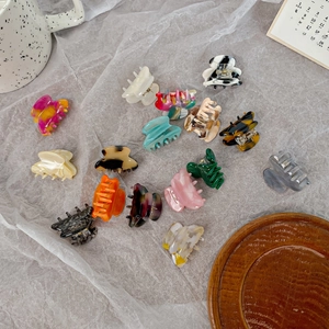 Minimalist acetate hair claws set in various patterns and colors on a soft fabric