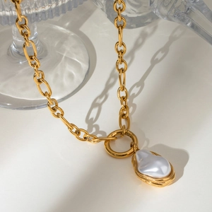 Gold chain necklace with baroque pearl pendant and OT buckle on white background
