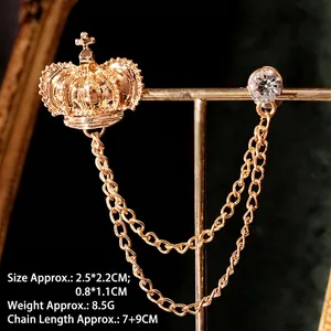 Detail of vintage gold crown lapel pin with rhinestones and double tassel chains