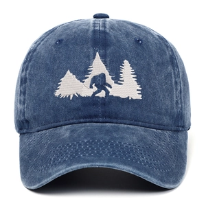 Dettaglio del ricamo Bigfoot e pini sul cappellino da baseball in denim blu lavato