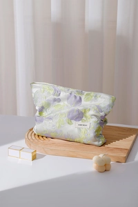 Macro detail of floral jacquard satin makeup bag showing fabric texture and H&R logo