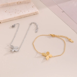 Detail of gold and silver lucky clover bracelets with crystal pavé and adjustable chains