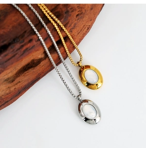 Detail of oval shell pendants in gold and silver finish with elegant box chains