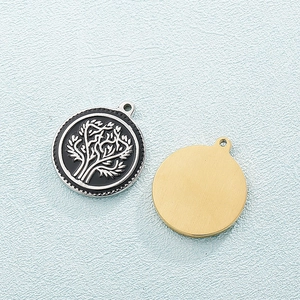 Titanium steel tree of life pendant in silver and gold finishes on a textured background