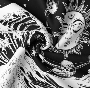 Close-up of black and white bohemian tapestry fabric with moon phases and sun patterns