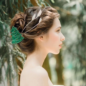 Close-up of a green Christmas tree hair claw with colorful dots on a woman's hair