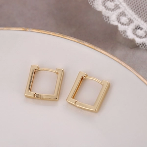 Minimalist gold square geometric stud earrings displayed on a white decorative plate