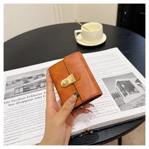 Detail of vintage orange pebbled leather wallet with gold metal push-lock closure