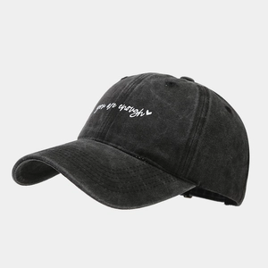 Detail of vintage washed charcoal baseball cap with 'you are enough' white embroidery