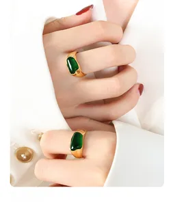 Detailed view of vintage gold irregular rings with deep green stones on a model