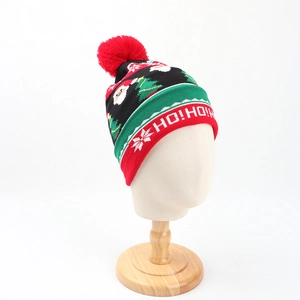Detail of Christmas knitted beanie with pom-pom, Santa patterns and HO! HO! embroidery