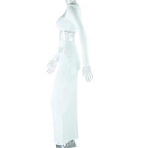 Détail d'une robe blanche à manches longues avec découpe à la taille et coupe ajustée