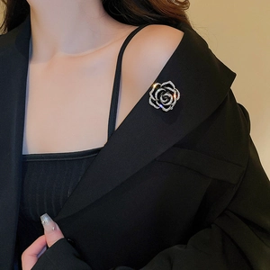 Gros plan d'une broche rose argentée étincelante avec strass sur un revers noir