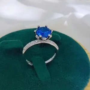 Macro detail of a 2-carat blue sapphire style ring featuring a six-prong silver setting
