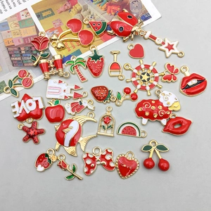 Detailed close-up of mixed red enamel alloy charms including cherry and heart shapes