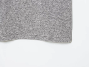 Close-up of grey knit fabric texture and high-quality hem stitching on the polo skirt set
