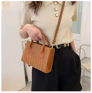 Close-up of woven PP square bag featuring tan faux leather trim and gold hardware details
